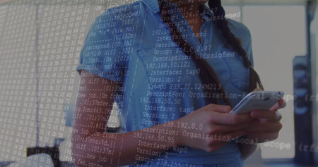 Holding smartphone, woman wearing denim shirt in modern office showing code overlay, copy space....