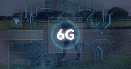 Man in cap and sneakers standing on grass field, with 6G symbol globe icon circuit overlay....