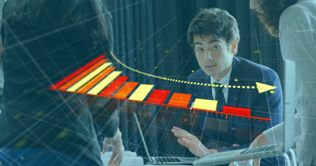 Native American man in navy suit presenting bar chart and arrow at conference table, with laptop....