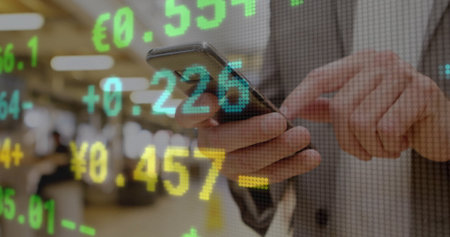 Tapping smartphone screen senior trader tracking currency overlays on trading floor, with suit....
