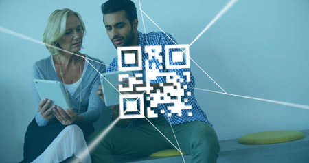Holding tablets coworkers scanning floating QR code on corporate lounge bench, with yellow cushions....