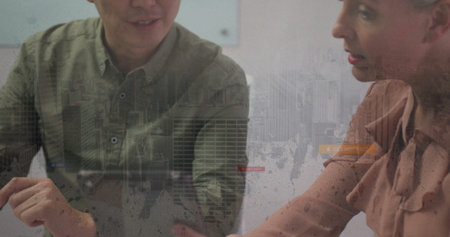 Discussing bar charts colleagues wearing business attire at meeting table, with skyline overlay....