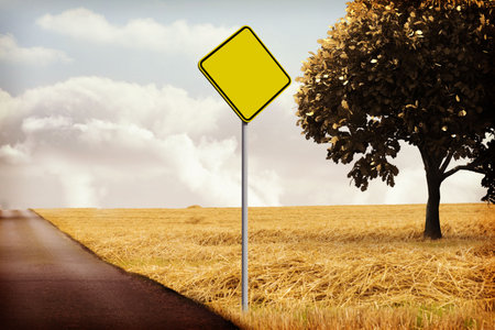 Blank yellow diamond traffic sign is standing beside road with wheat field and tree, flat design. Rural, farmland, agriculture, landscape, signage, nature, tranquilityの写真素材