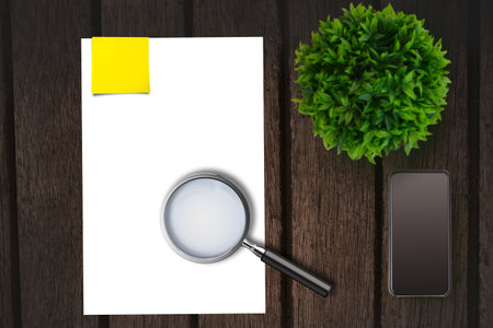 Magnifying glass on paper on the side of smartphoneの写真素材