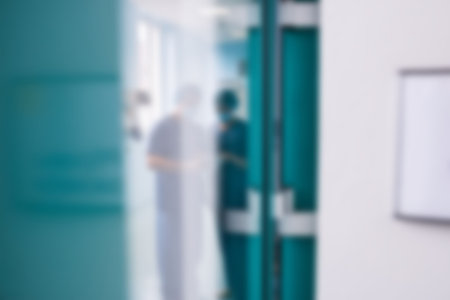 Blurry view of two surgeons interacting with each other in corridorの写真素材
