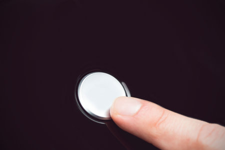White finger pressing a small white buttonの写真素材
