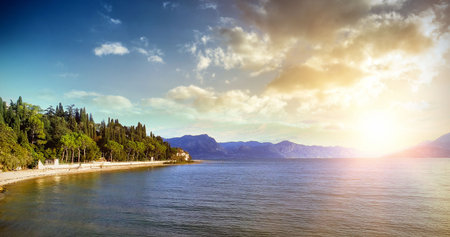 Lakefront lighting by sunset between mountainの写真素材