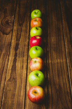 Red and green apples on wooden tableの写真素材
