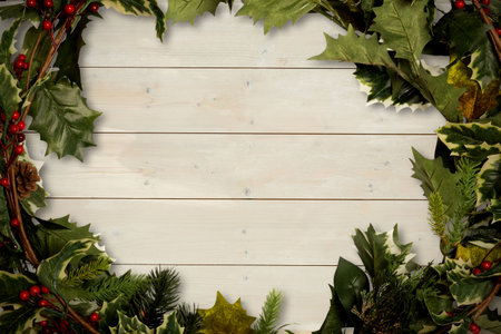 Holly twigs over wooden planks with copy space