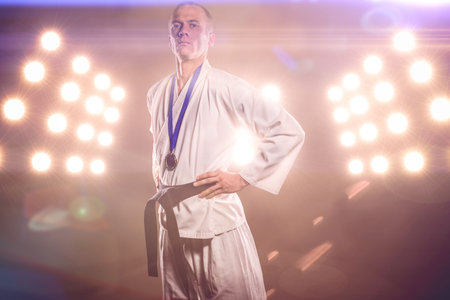 Portrait of karate player with medals against illuminated floodlightsの写真素材
