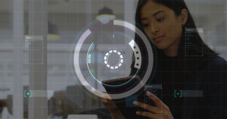 Asian woman in blazer analyzing AR data on touchscreen behind glass partition at office, copy space. Technology, innovation, collaboration, futuristic, corporate, digital, high-techの写真素材