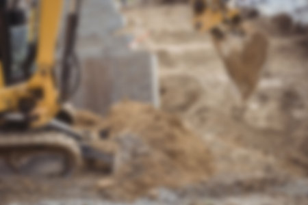 Defocused image of bulldozer moving heap of mud at construction siteの写真素材