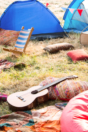 Tents by guitars and chairs on grassy fieldの写真素材