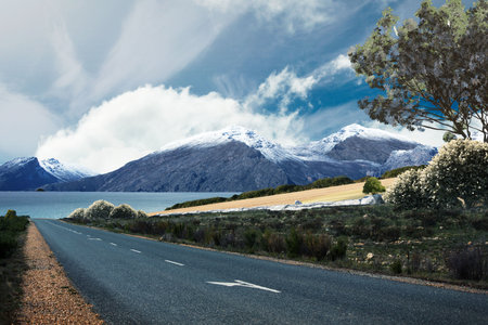 Flat design illustration is showing two-lane asphalt road with white dashed lines running past lake. Scenic, landscape, wilderness, tranquility, travel, outdoors, natureの写真素材