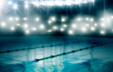 Central pool lane is glimmering under stadium lights with floating dividers in flat design. Sport, aquatic, minimalism, reflection, symmetry, fitness, waterの写真素材