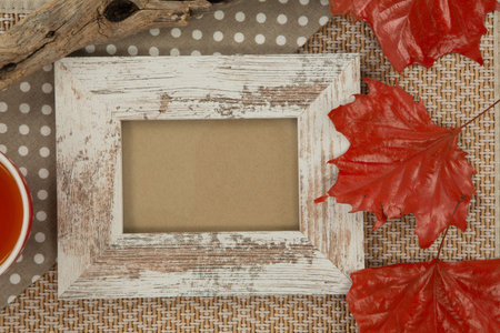 Photo frame and maple leaf on wooden table, Close-up