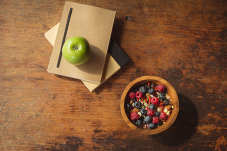 Directly above shot of berries in bowl by books