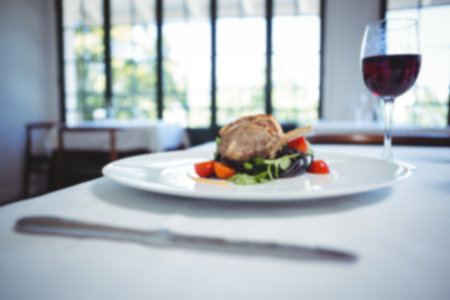 Lamb chop in plate and wineglass on tableの写真素材