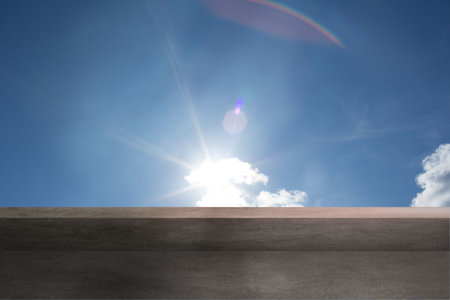 Bright sun is shining over flat concrete ledge in flat design, with lens flare, white clouds....