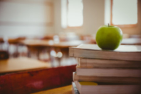 Green apple on stacked books over table in room