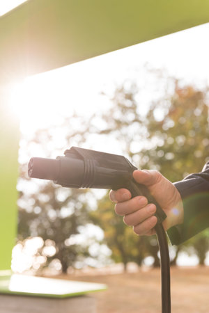 Close-up of man holding charging plug