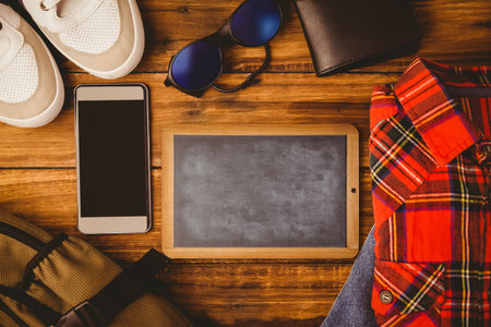 Laying flat on wooden table, showing chalkboard, phone, sneakers, plaid shirt and backpack. Casual,...