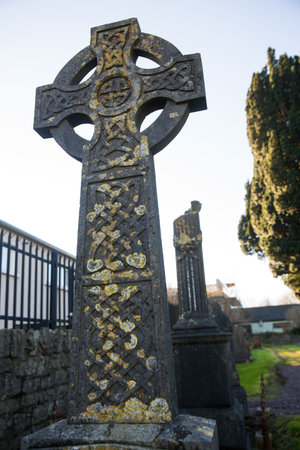 Low angle view of tombstone by wall against skyの写真素材