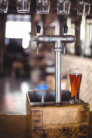 Beer glass on beer filling machine at factoryの写真素材