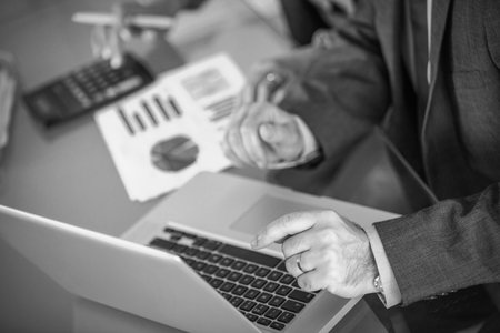 Mid section of executive using laptop in officeの写真素材