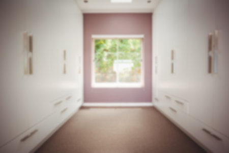 Defocused image of window on wall amidst storage compartments at homeの写真素材