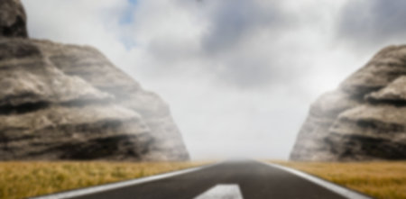 Diminishing view of road amidst rocky mountain against cloudy skyの写真素材