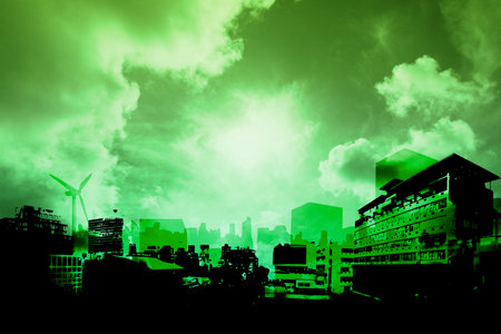 Green-tinted urban skyline is glowing under bright sun with wind turbine and clouds in flat design. Metropolis, sustainability, graphicart, renewableenergy, environmental, ecofriendly, cityscapeの写真素材