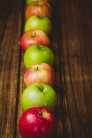 Red and green apples on wooden tableの写真素材