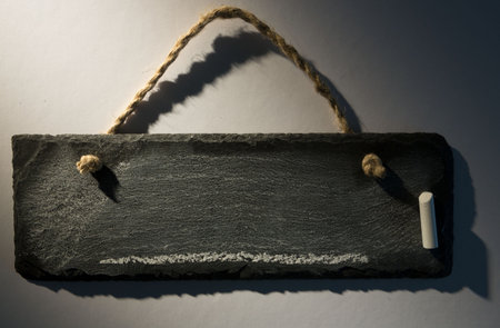 Hanging chalkboard on dark backgroundの写真素材