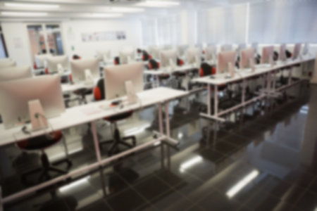 Defocused image of computers in illuminated office