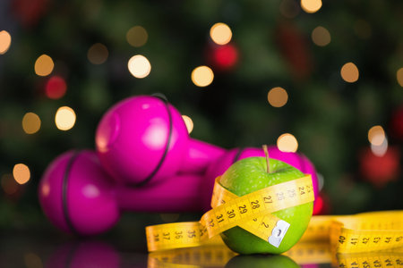 Green apple is sitting wrapped in tape on tabletop with pink dumbbells, bokeh in flat design....