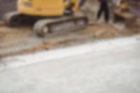Defocused image of bulldozer levelling mud at construction site