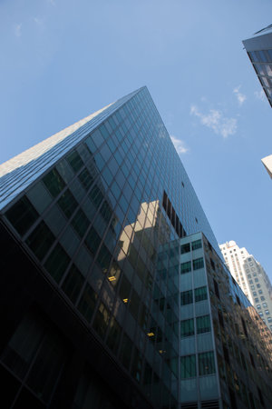 Low angle view of modern glass buildings against sky on sunny day