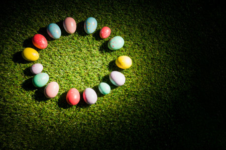 Overhead view of colorful Easter eggs in circle on grass at garden