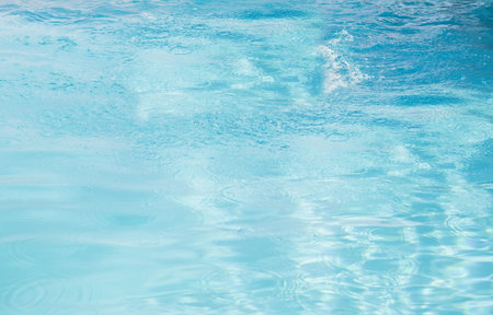 Flat design water surface is shimmering under bright sunlight with subtle ripples and reflections....