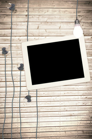 Tablet and plugs on wooden background