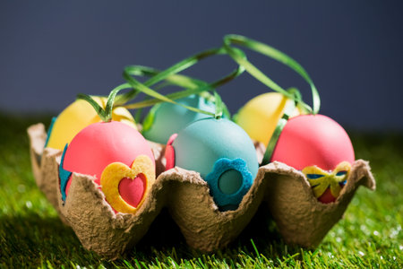 Close-up of decorated Easter eggs in crate on grassy fieldの写真素材