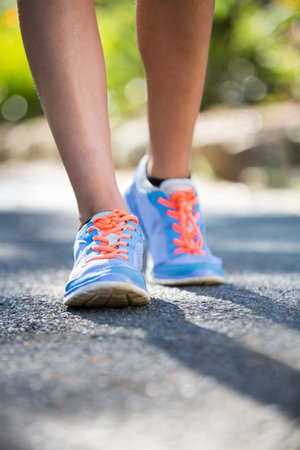 Low section of woman jogging on road