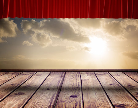 Flat design stage is showing wooden planks and featuring red velvet curtain under sunlit clouds. Theatrical, outdoor, rustic, scenic, dramatic, sunset, performanceの写真素材