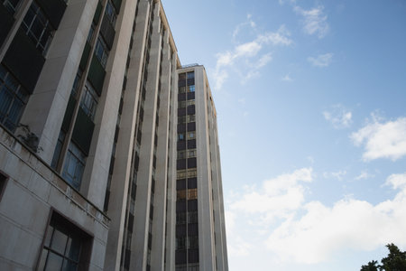 side view of office building against cloudy blue skyの写真素材