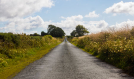 Diminishing view of asphalt road amidst field against skyの写真素材