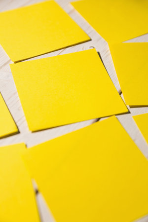 Close-up of yellow papers fallen on wooden floorの写真素材