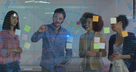 Team in suits collaborating at glass board with sticky notes and tablet in meeting room. Collaboration, brainstorming, teamwork, innovation, strategy, communication, creativeの写真素材