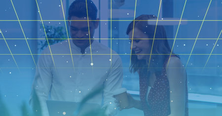 Collaborating colleagues using laptop with digital grid and data points overlay. Teamwork,...