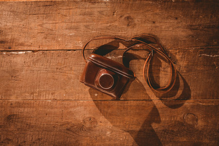 Old school camera on wooden floor overhead shotの写真素材